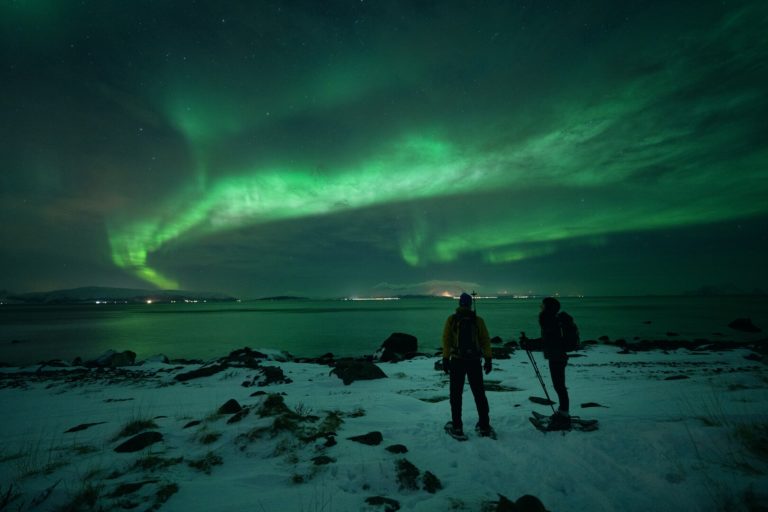 The Northern Lights play with the clouds at Lyngstuva, the northern tip of the Lyngen Peninsula. The islands of Karlsøy and Vanna are in the west © Petr Pavlíček / Visit Lyngenfjord